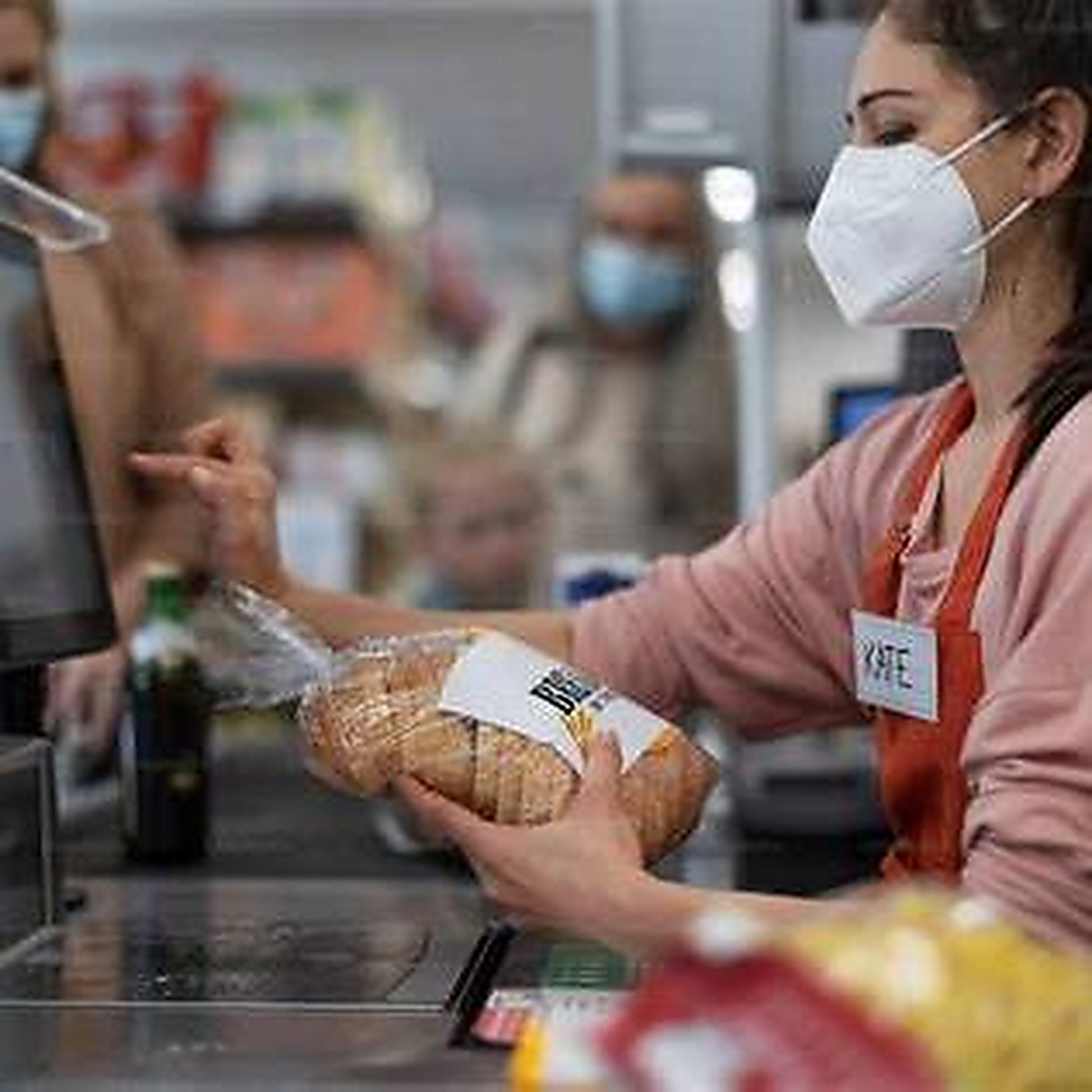 Operadora de caixa em mercado passando produtos